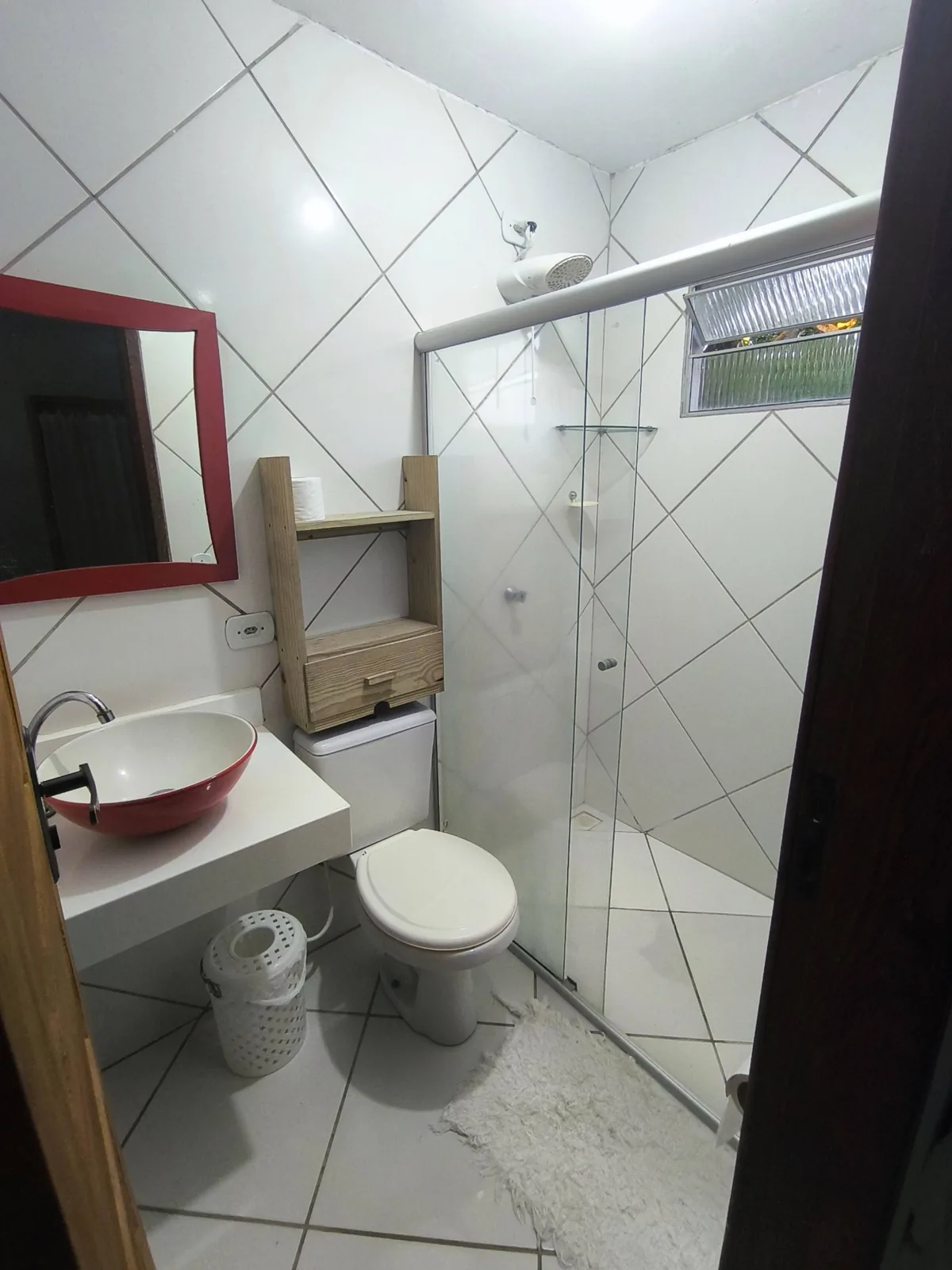 Segundo banheiro da casa de temporada em Trancoso BA com box, pia e nicho de madeira