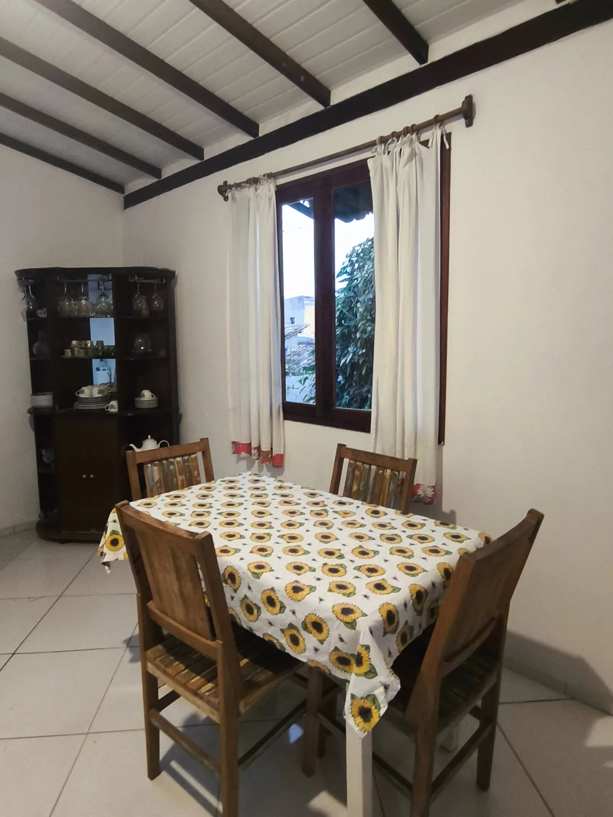 Sala de jantar com janela e vista para o jardim na casa de temporada em Trancoso, Bahia